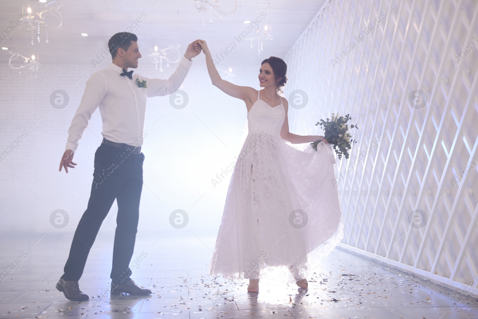 Photo of Happy newlywed couple dancing together in festive hall