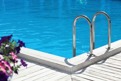 Modern swimming pool with step ladder outdoors