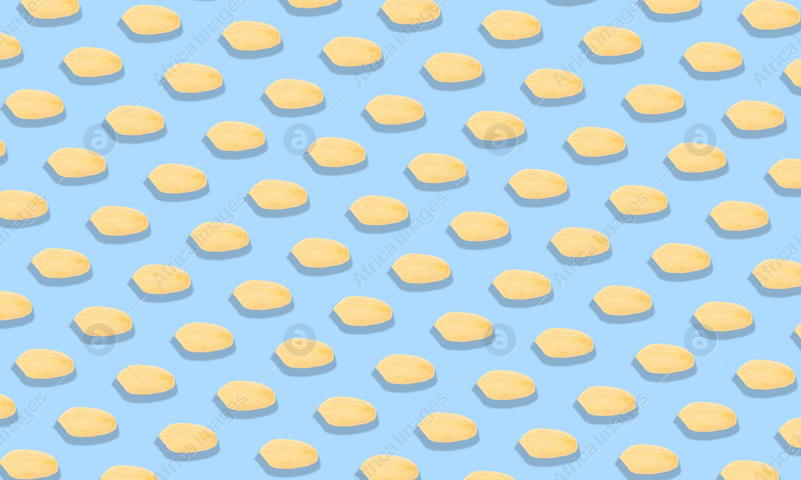 Image of Pattern of peeled peanuts on light blue background