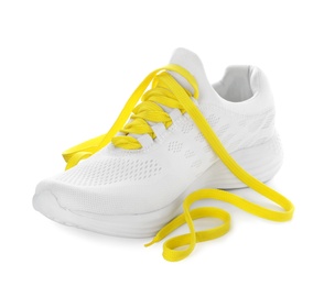 Photo of Stylish sneaker with yellow shoelaces on white background