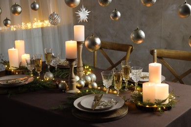 Photo of Christmas table setting with burning candles and festive decor