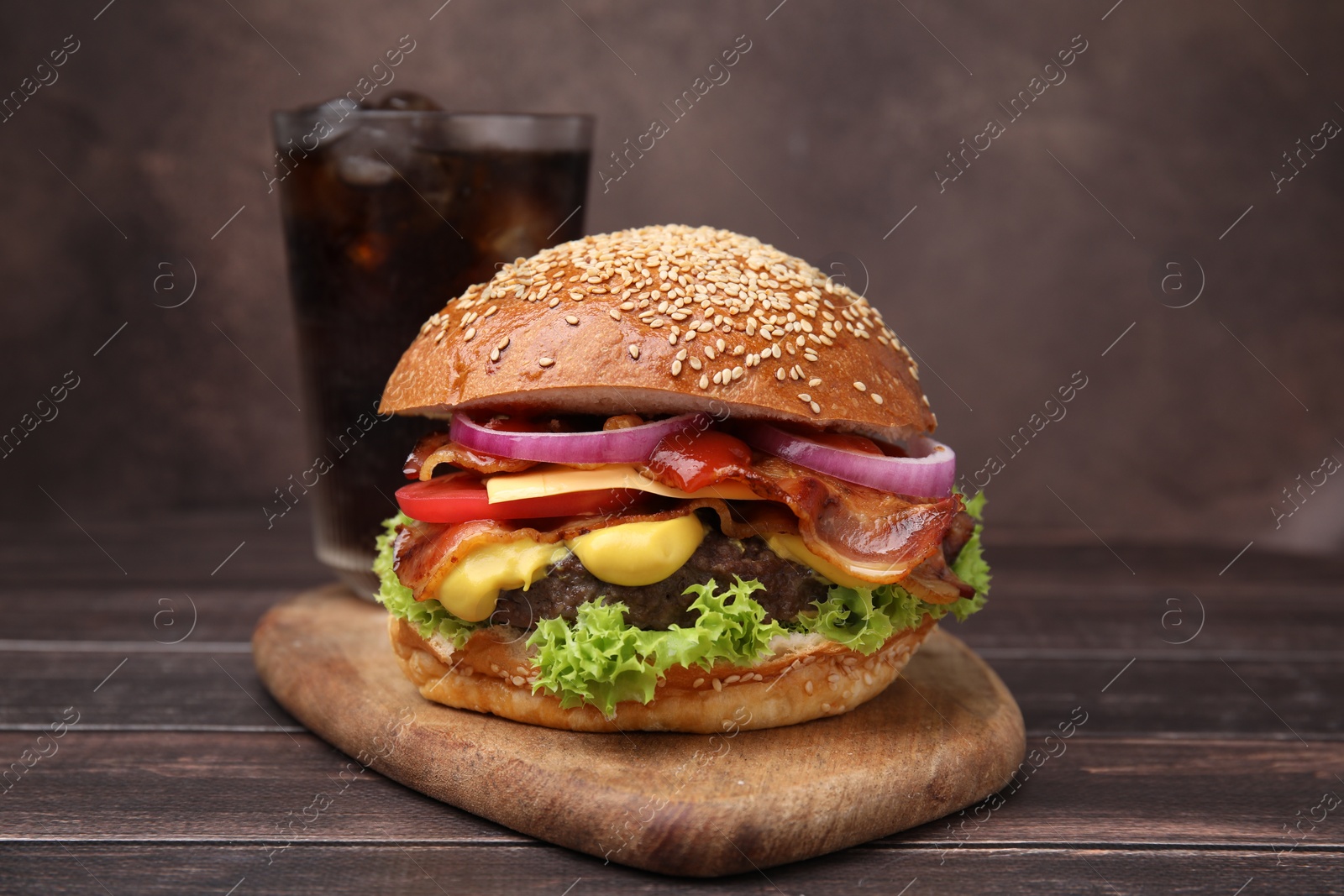 Photo of Delicious burger with bacon, patty and vegetables on wooden table