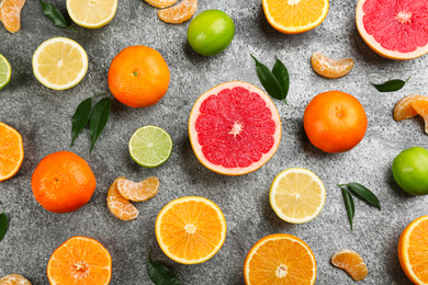 Photo of Flat lay composition with tangerines and different citrus fruits on grey background