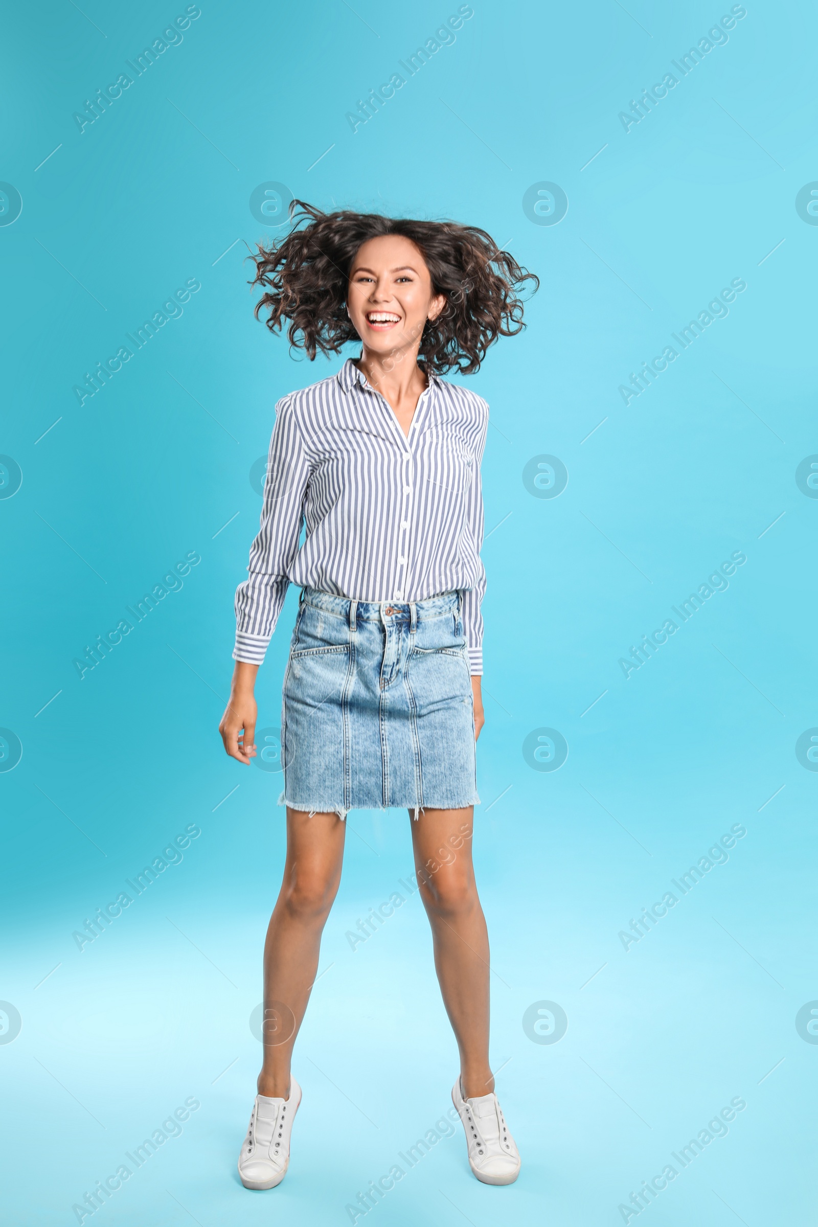 Photo of Happy young woman in casual outfit on blue background