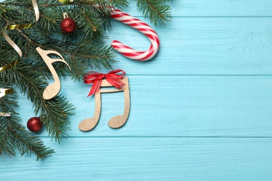 Flat lay composition with music notes on light blue wooden background, space for text. Christmas celebration