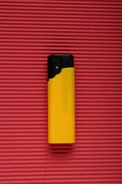 Stylish small pocket lighter on red corrugated fiberboard, top view