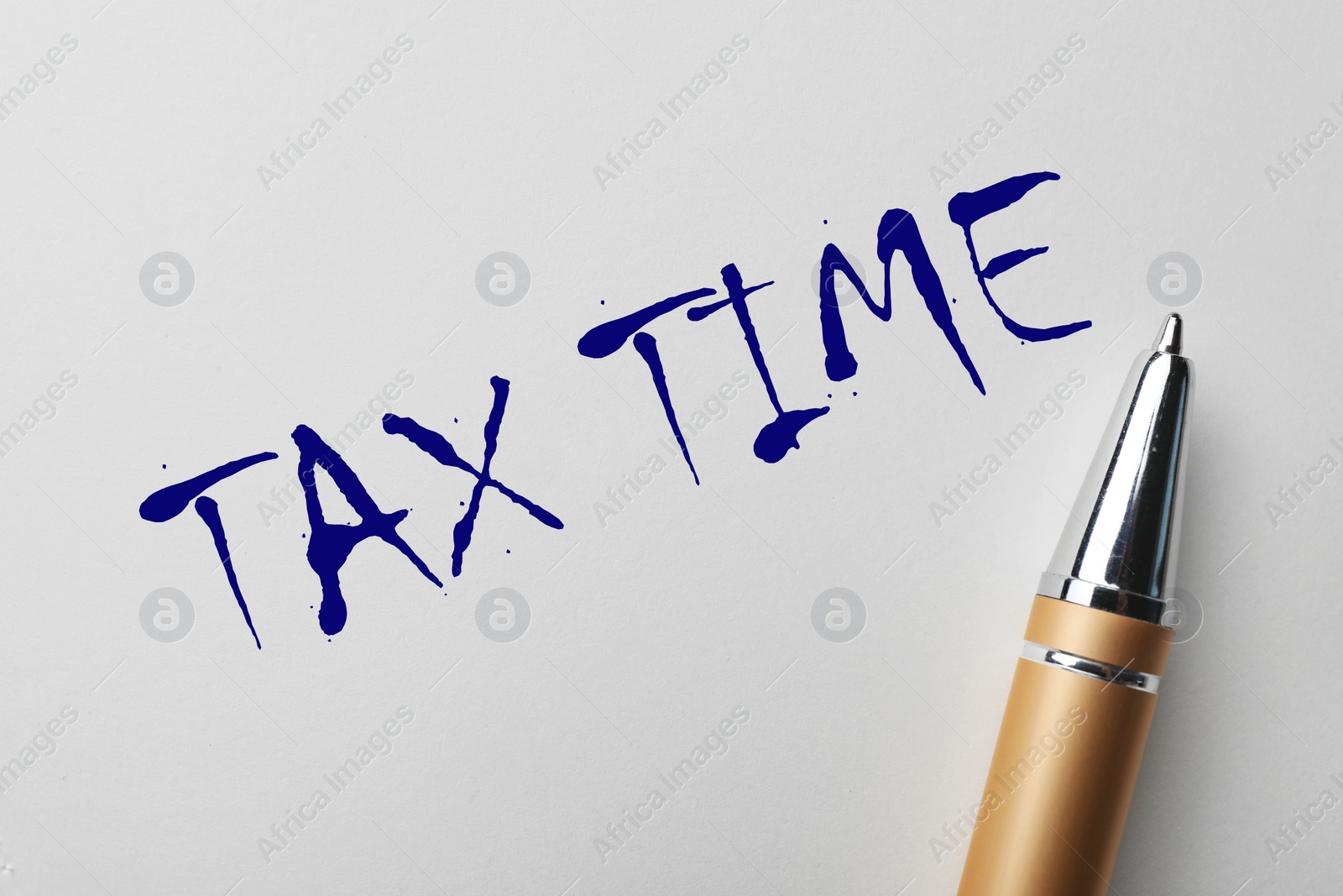 Image of Written words TAX TIME and pen on white paper, top view