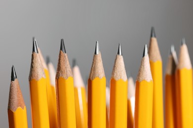 Photo of Many graphite pencils on grey background, macro view