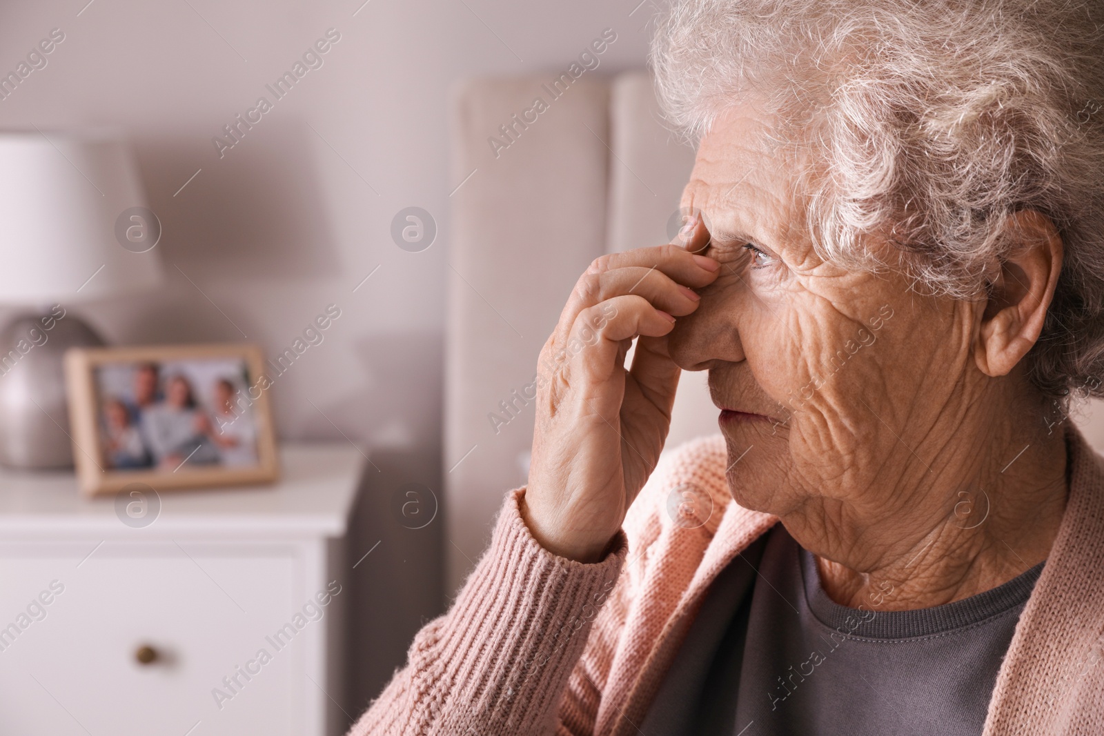 Photo of Senior woman with headache in room at home. Space for text