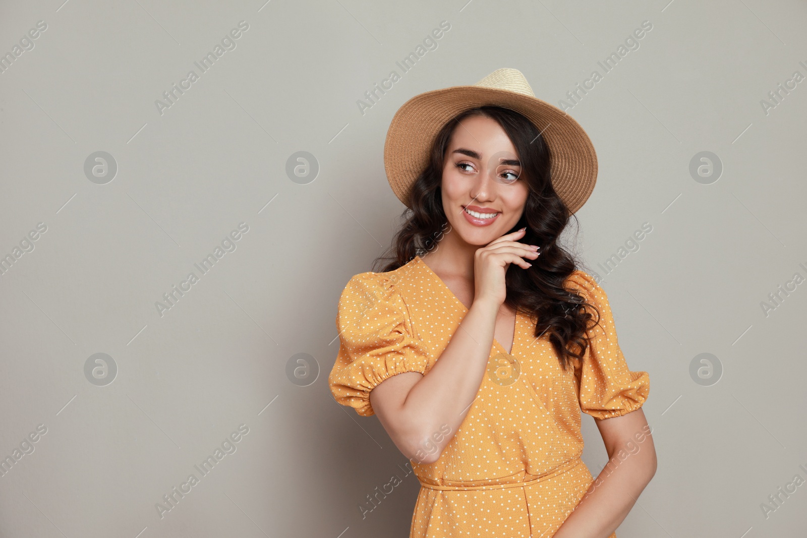 Photo of Beautiful young woman with straw hat on beige background. Space for text