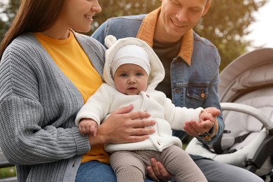 Happy parents with their adorable baby in park