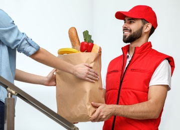 Young man delivering food to customer indoors