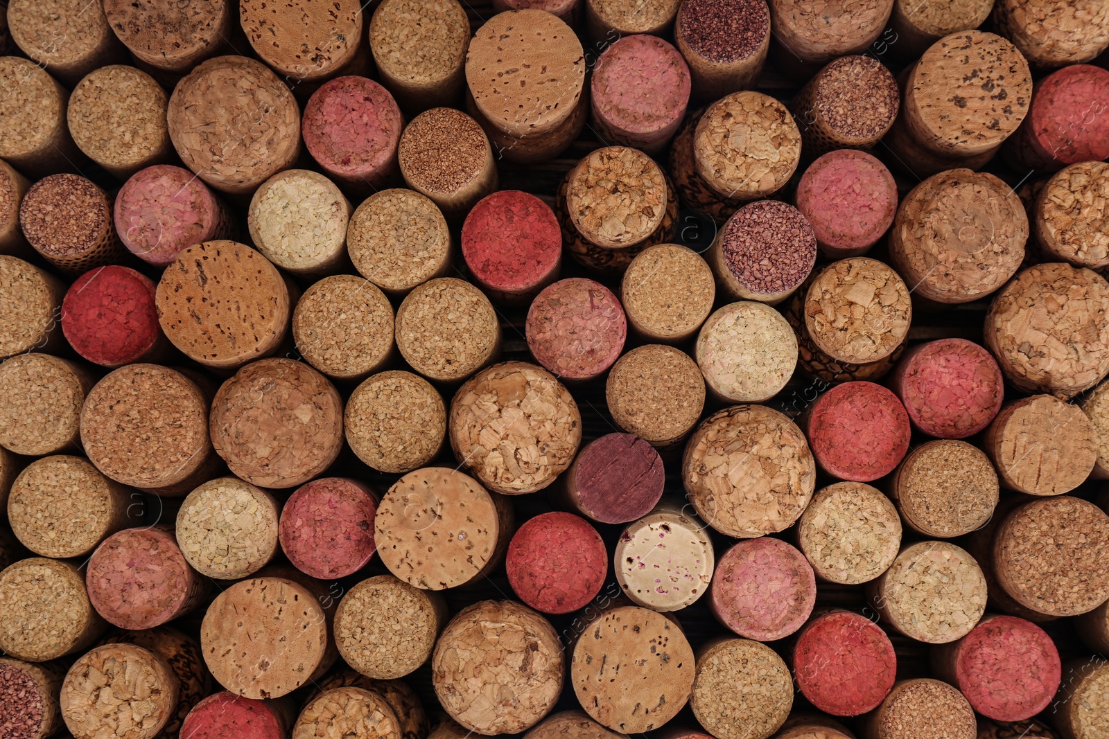 Photo of Many corks of wine bottles as background, top view