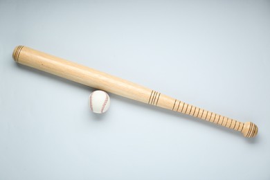 Photo of Wooden baseball bat and ball on light grey background, flat lay. Sports equipment