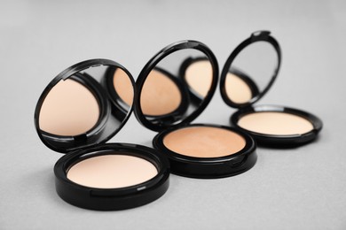 Photo of Open face powders with mirrors on light grey background