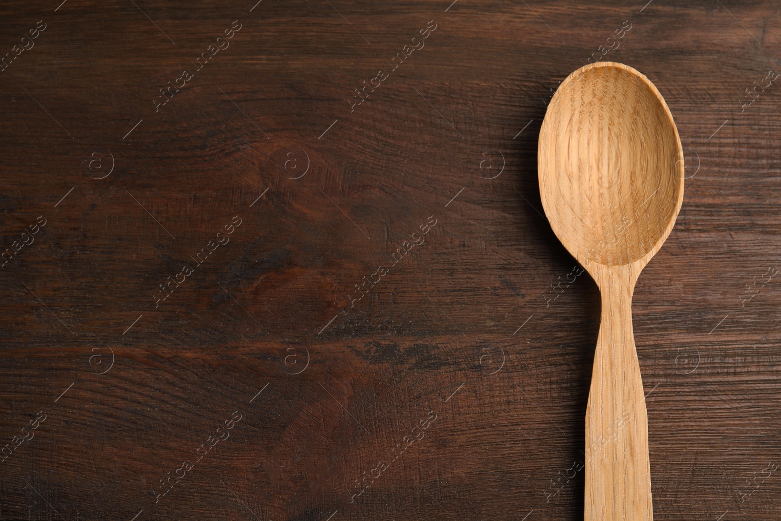 Photo of Handmade wooden spoon on rustic table, top view. Space for text