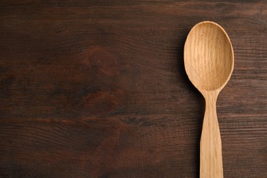 Photo of Handmade wooden spoon on rustic table, top view. Space for text