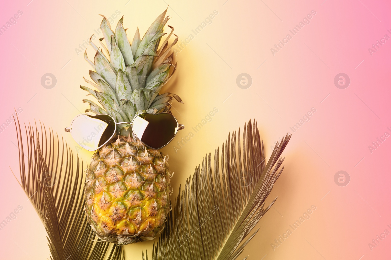Image of Pineapple with sunglasses and palm leaves on color background, flat lay. Summer party
