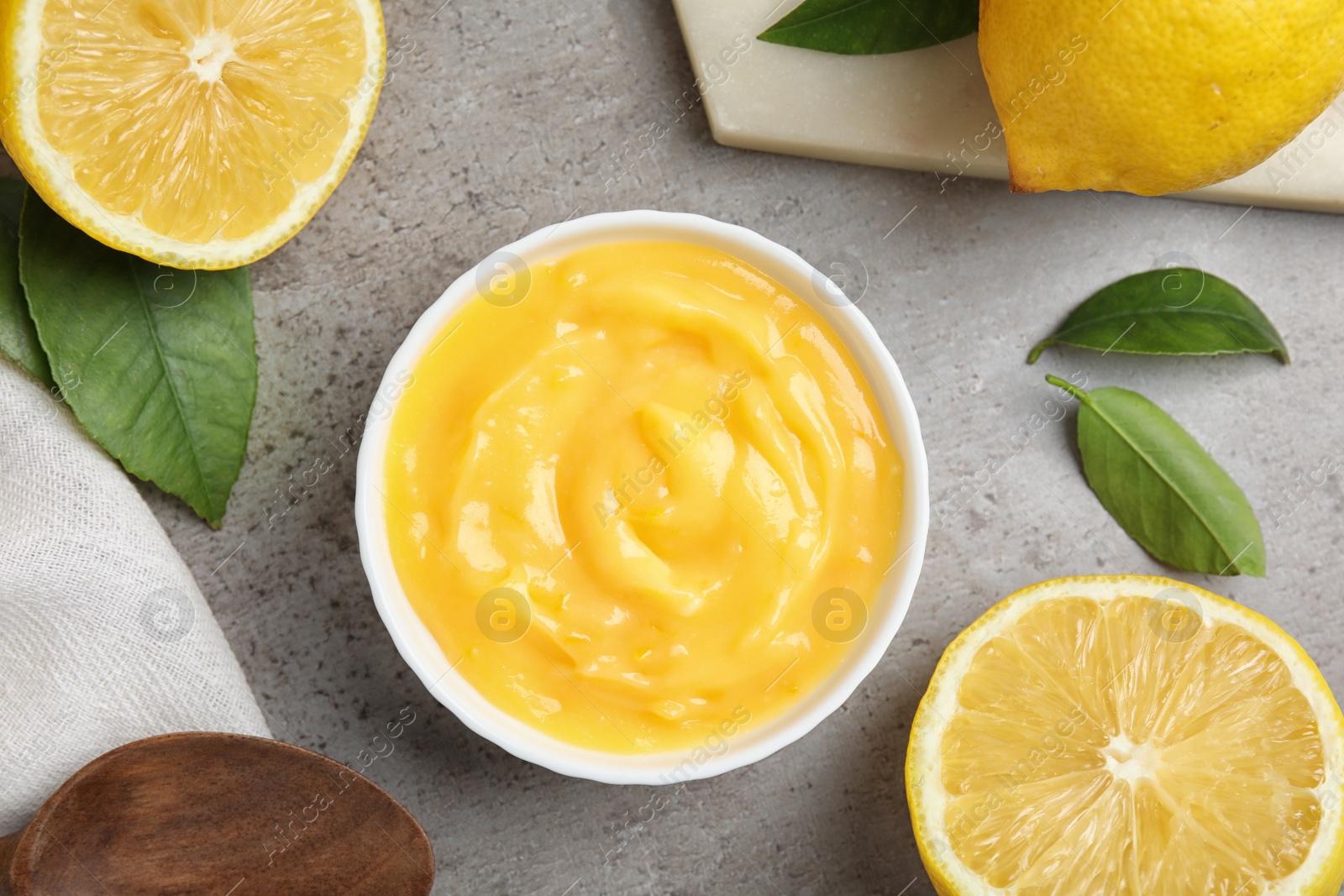 Photo of Delicious lemon curd in bowl on grey table, flat lay