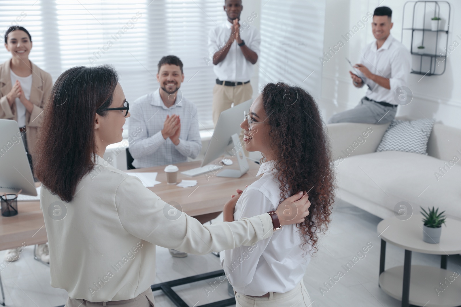 Photo of Boss introducing new employee to coworkers in office