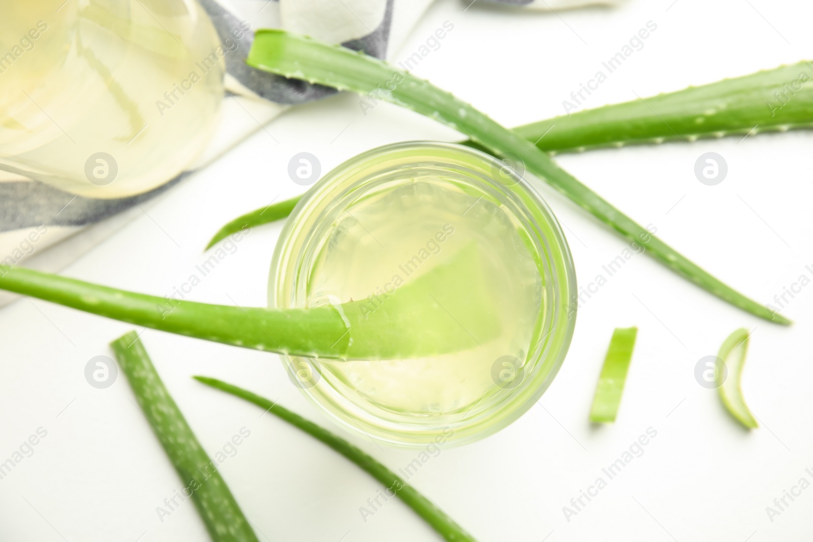 Photo of Fresh aloe drink in glass and leaves on white background, flat lay