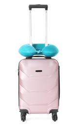 Photo of Light blue travel pillow on suitcase against white background