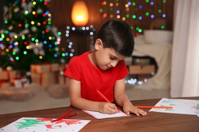 Photo of Little child writing letter to Santa at home. Christmas celebration