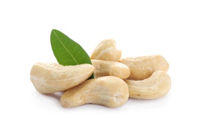 Photo of Pile of tasty organic cashew nuts and green leaf isolated on white