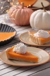 Fresh homemade pumpkin pie with whipped cream on table