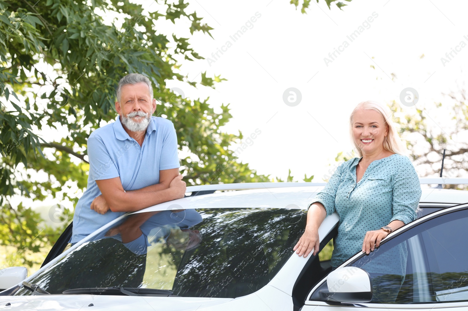 Photo of Happy senior couple standing near car outdoors