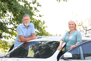 Photo of Happy senior couple standing near car outdoors