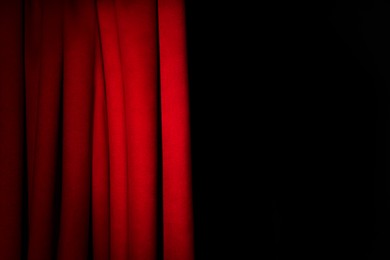 Photo of Open elegant red front curtains on black background. Space for text