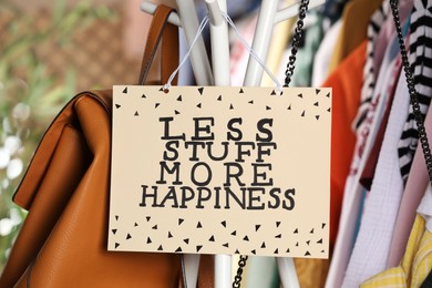 Plate with words Less Stuff More Happiness near bags and clothes