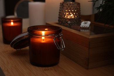 Lit candles on wooden dressing table indoors