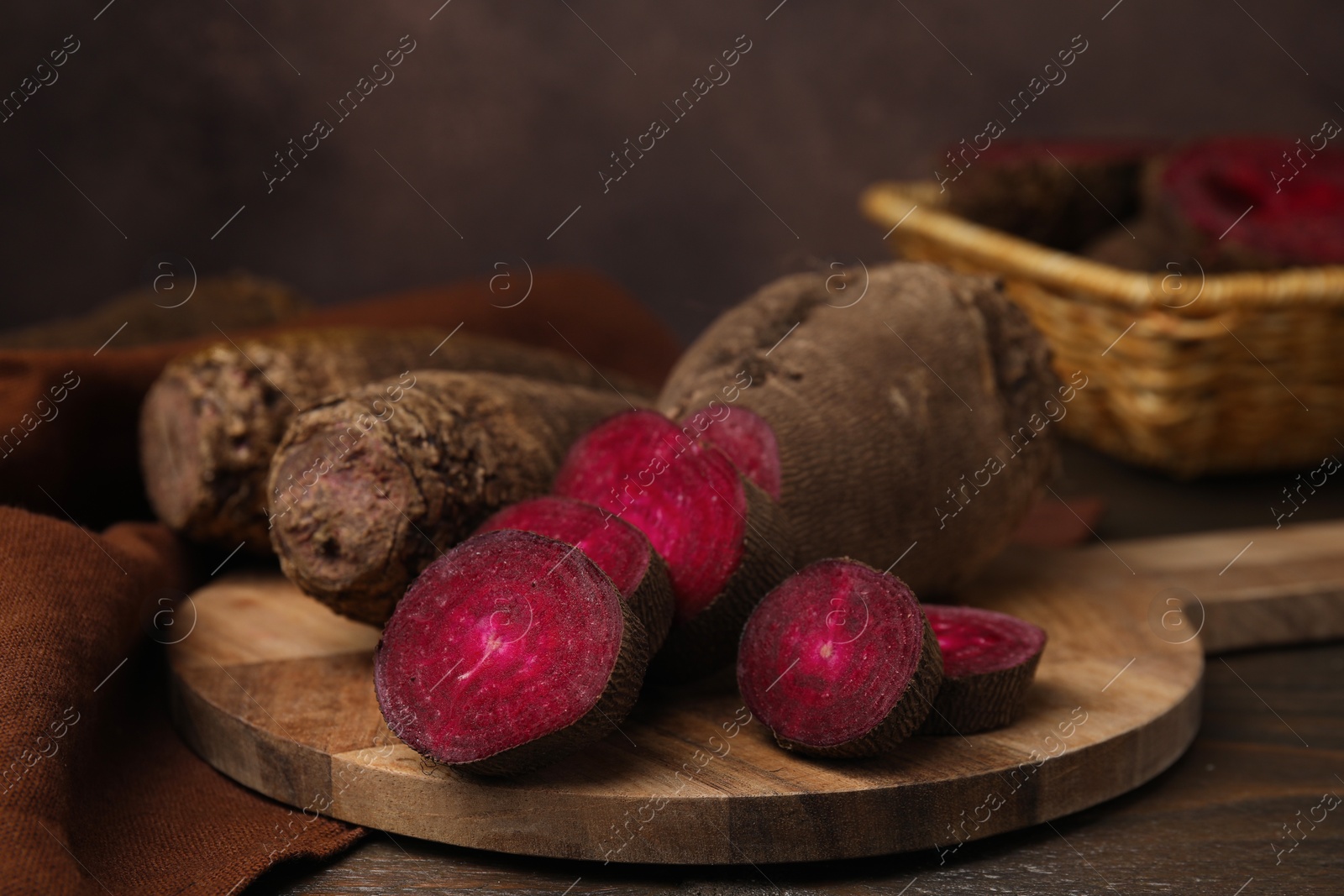 Photo of Whole and cut red beets on table, closeup