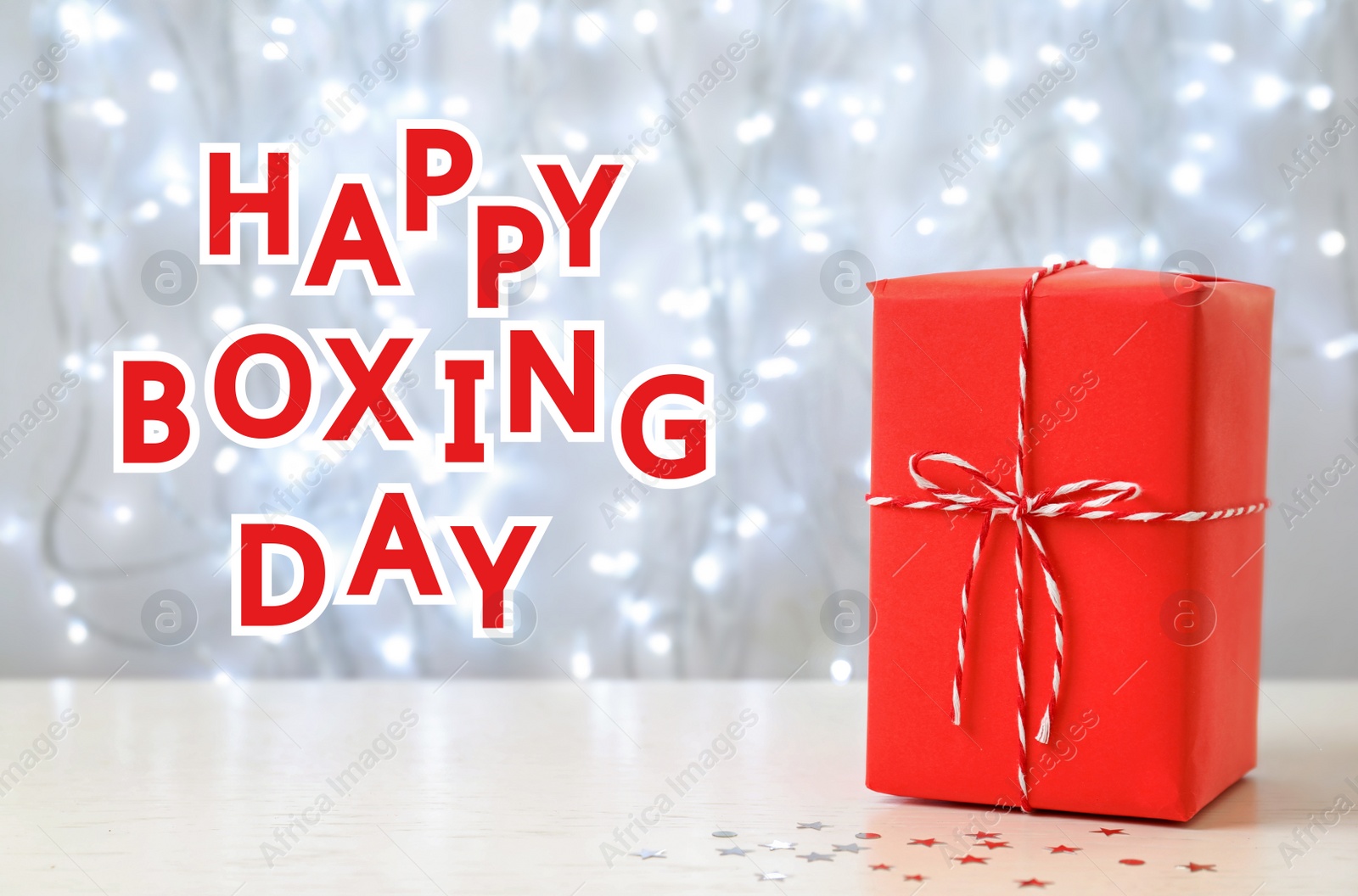 Image of Text Happy Boxing Day near gift against blurred lights
