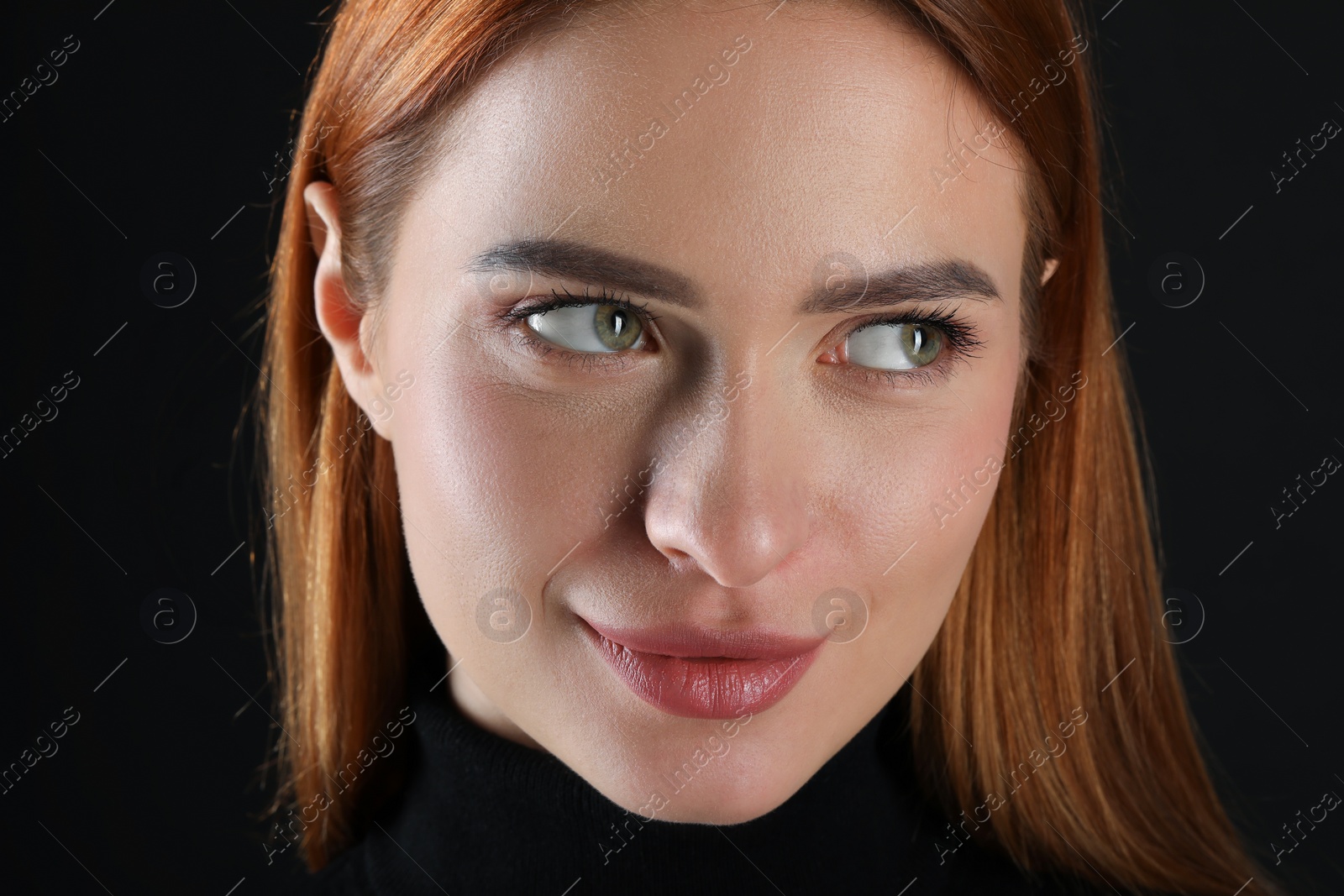 Photo of Evil eye. Young woman with scary eyes on black background, closeup