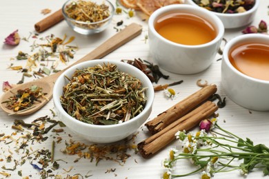 Photo of Fresh brewed tea and dry leaves on white wooden table