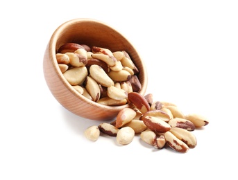 Wooden bowl with Brazil nuts on white background