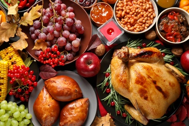 Traditional Thanksgiving day feast with delicious cooked turkey and other seasonal dishes served on table, top view