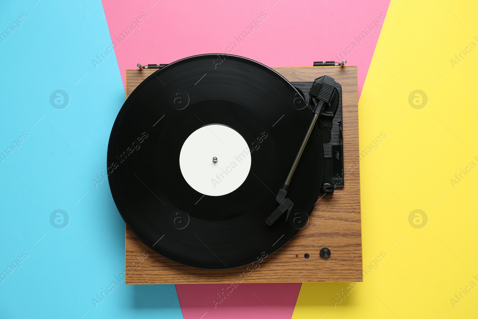 Photo of Turntable with vinyl record on color background, top view