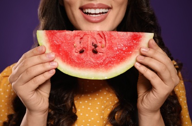 Photo of Beautiful young woman with watermelon on purple background, closeup
