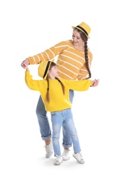 Happy woman and daughter in stylish clothes on white background