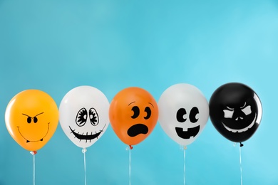 Photo of Spooky balloons for Halloween party on blue background