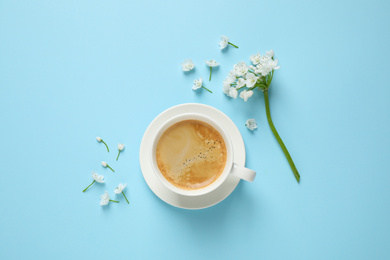 Photo of White flowers and coffee on light blue background, flat lay. Good morning