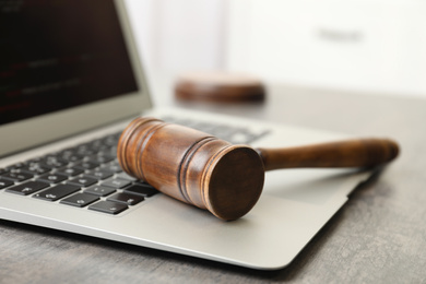 Photo of Laptop and gavel on table indoors, closeup. Cyber crime
