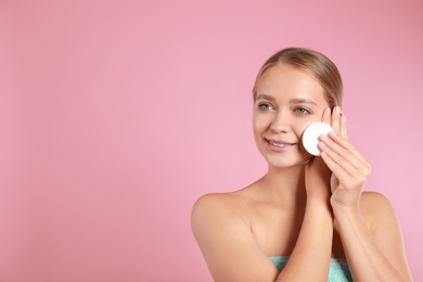 Beautiful young woman with cotton pad on pink background. Space for text