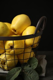 Photo of Fresh ripe organic quinces with leaves on table, closeup