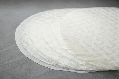 Photo of Sheets of dry rice paper on grey table, closeup