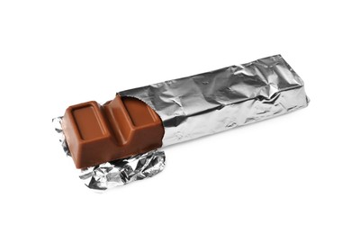 Photo of Delicious chocolate bar wrapped in foil on white background